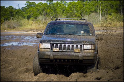 1996 Ford F-150 - A 1996 Jeep Grand Cherokee navigates a challenging muddy terrain, off-road terrain.