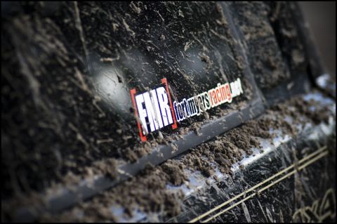1996 Ford F-150 - A close-up of a muddy truck's side panel reveals a racing sticker.