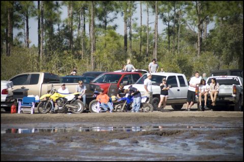 1996 Ford F-150 - Group of people and dirt bikes with several pickup trucks parked nearby at an outdoor event.