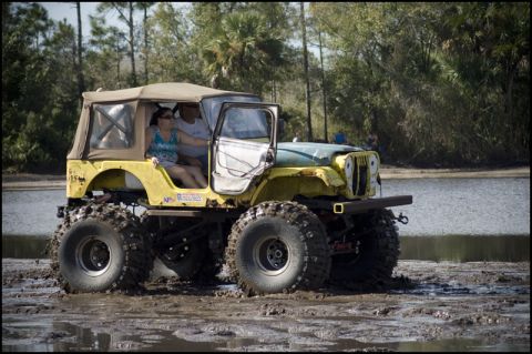 1996 Ford F-150 - Modified Jeep CJ-5 with large tires navigating through mud.