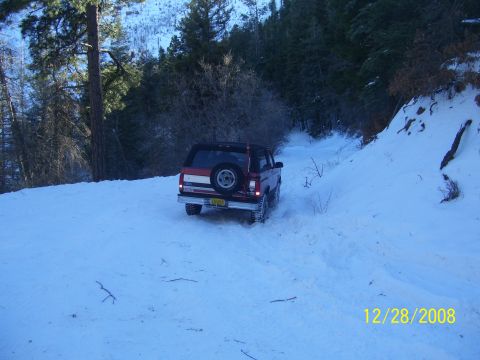 1993 Ford Bronco - 1993 Ford Bronco navigating a snowy trail in a forest.