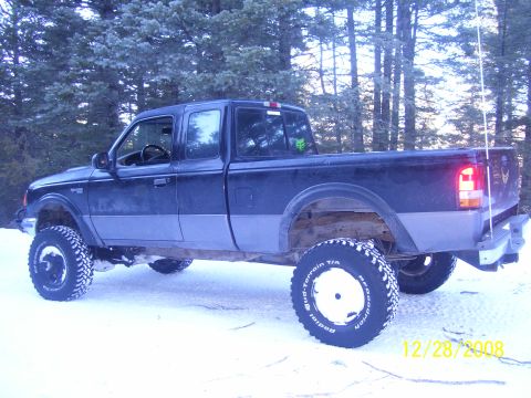 1993 Ford Bronco - A lifted Ford Ranger pickup truck sits in the snow, its off-road tires ready for winter conditions.