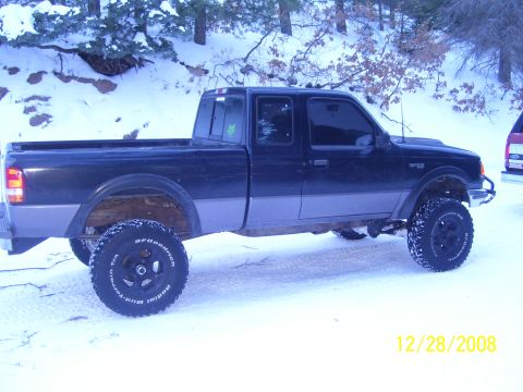 1993 Ford Bronco - A lifted black Ford Ranger pickup truck is parked in a snowy landscape.