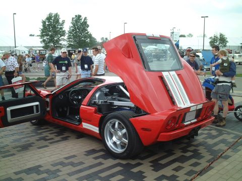2004 Ford GT - A red sports car is displayed with its hood and trunk open, revealing the engine and interior details.