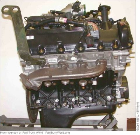 2007 Ford Mustang - An engine assembly with black valve covers and a silver exhaust manifold is shown, mounted on a stand.