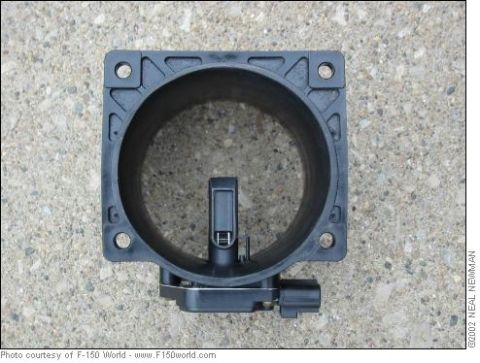 2007 Ford Mustang - A black plastic mass air flow sensor is shown against a concrete background.