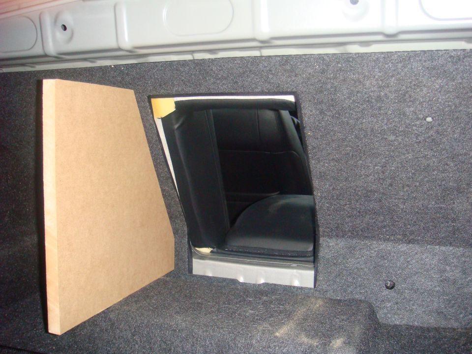 Carpeted vehicle cargo area with an opening and a fabricated panel