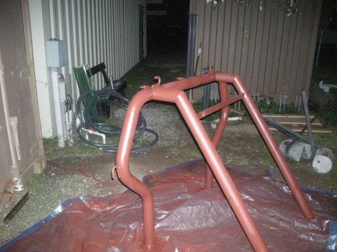 1991 Ford Bronco - A red painted roll cage is shown on plastic sheeting in an outdoor setting.