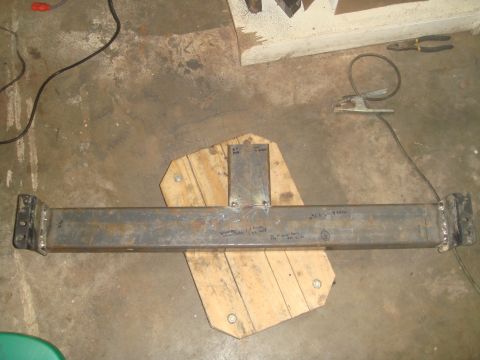 1992 Ford Bronco - A custom-fabricated steel beam, likely a component for a vehicle modification, rests on a wooden support.