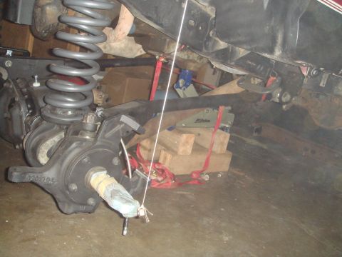 1992 Ford Bronco - Vehicle's front axle assembly with suspension components, supported by blocks and straps.