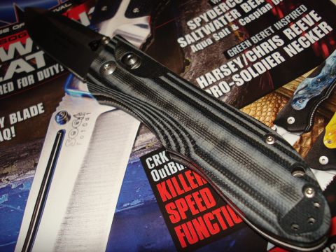 2000 Ford Crown Victoria - A tactical folding knife with a patterned handle is displayed on top of several knife enthusiast magazine pages.