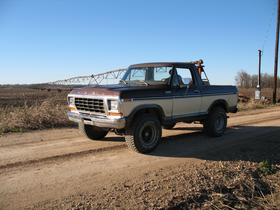 Two-tone brown and tan Ford Bronco on a dirt road
