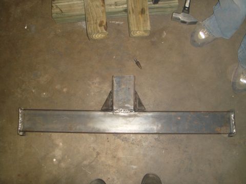 1992 Ford Bronco - A welded steel hitch receiver assembly is laid out on a concrete floor, with wooden beams and tools visible in the background.