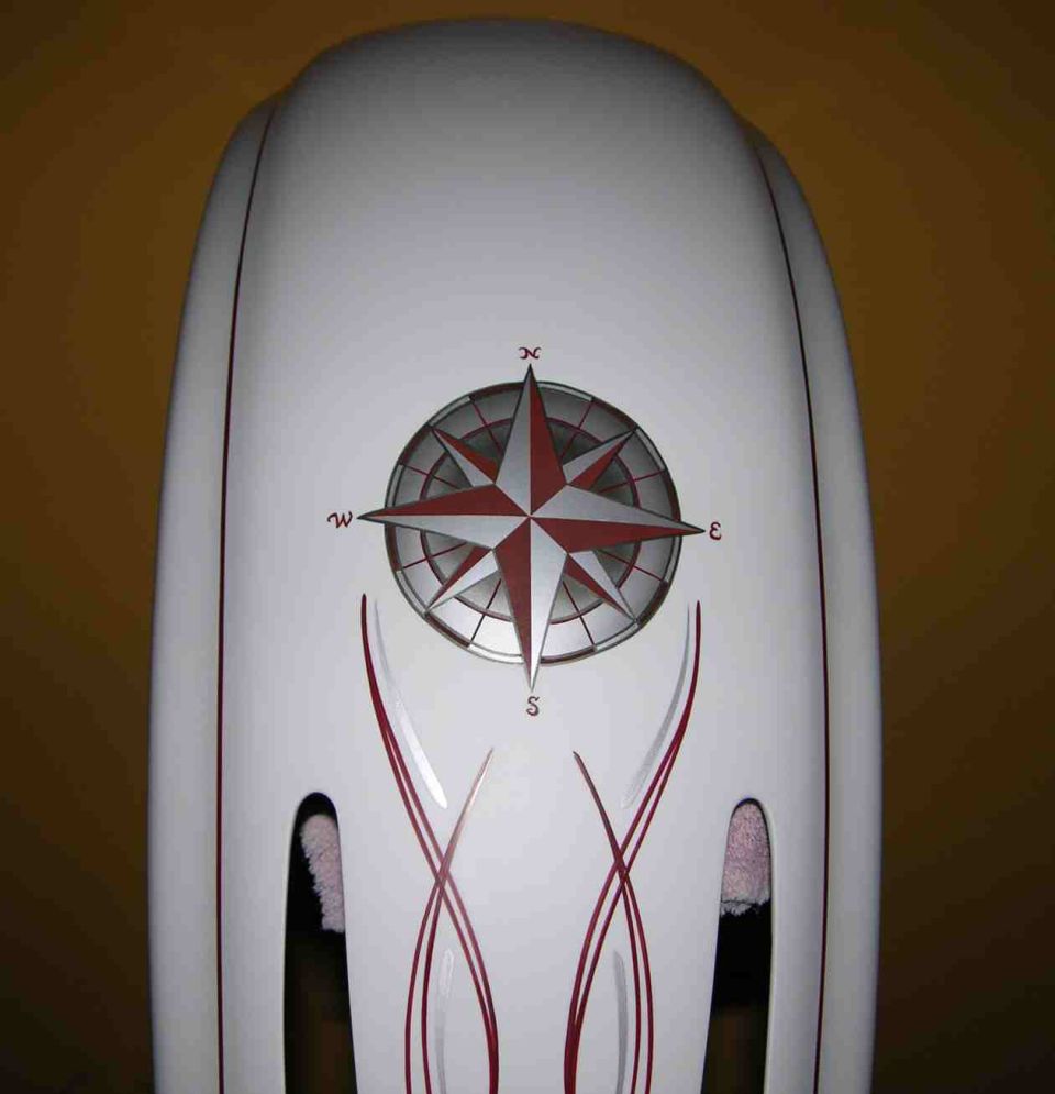 White motorcycle fender with red pinstripes and a red and silver compass rose graphic