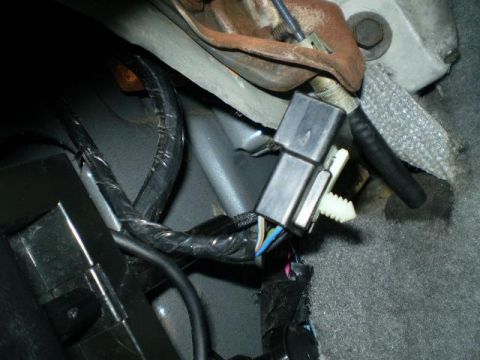 1996 Ford Bronco - A close-up view shows a black electrical connector with a white plastic clip attached to a wiring harness. The connector is situated near a…