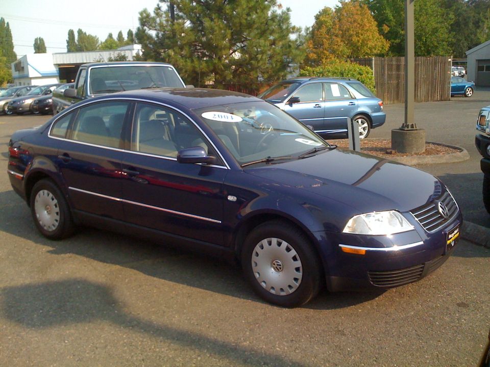 Dark blue Volkswagen Passat sedan with 2004 windshield sticker on a dealer lot
