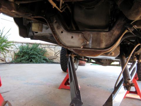 1996 Ford Bronco - This is an underside view of a 1996 Ford Bronco that has been jacked up and is supported by jack stands. A metal reinforcement plate has be…