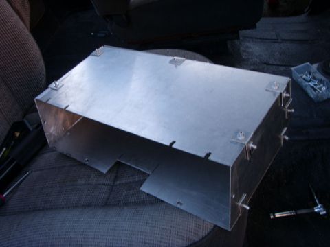 1978 Ford Bronco - A custom-made aluminum box with visible fasteners sits on a vehicle seat. Tools and a small container of hardware are visible nearby.