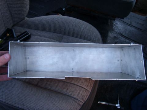 1978 Ford Bronco - A person's hand holds a rectangular aluminum box with visible screws on the sides and bottom. The box is positioned over the textured fabri…