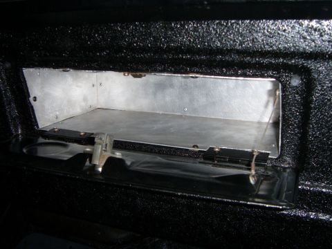1978 Ford Bronco - A custom aluminum storage compartment is installed inside a vehicle, likely a truck bed or SUV cargo area, with a hinged black metal door a…