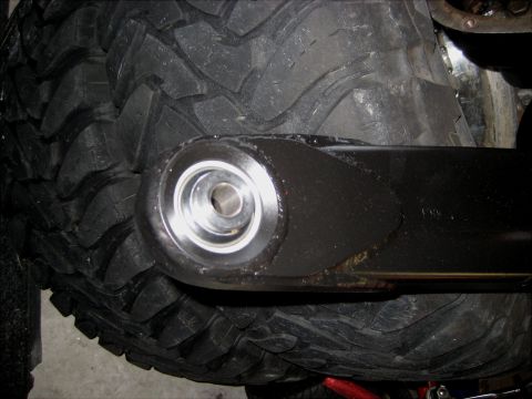 1996 Ford Bronco - A close-up view of a black suspension control arm attached to a large, aggressive off-road tire on a 1996 Ford Bronco.