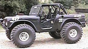 1991 Ford Bronco - A heavily modified black Ford Bronco is shown from the side, featuring oversized off-road tires, a roll cage, and custom doors. The vehicle…