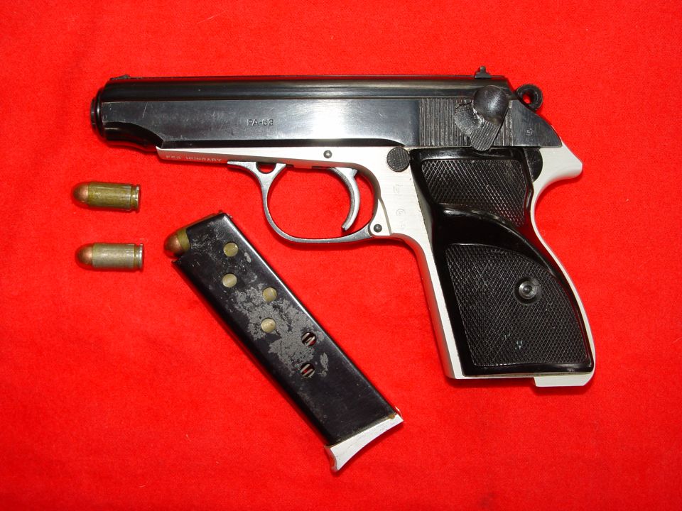 Semi-automatic pistol with magazine and cartridges on red background.