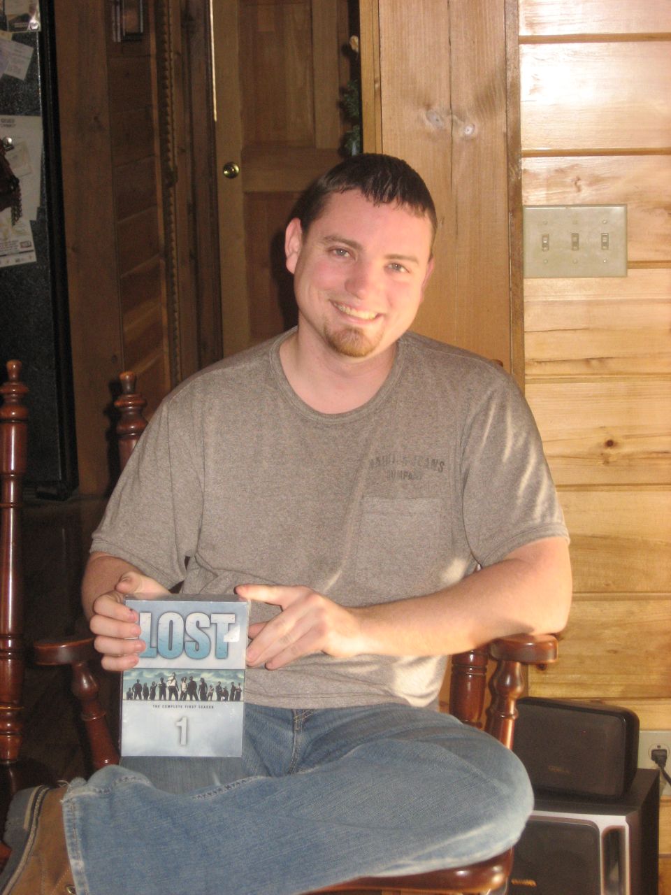 Man holding the complete first season DVD box set of the TV show LOST