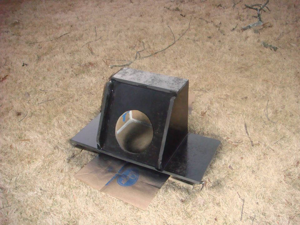 Black fabricated steel box with a round hole sitting on grass
