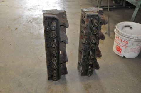 1996 Ford Bronco - Two engine cylinder heads are shown, each with multiple valve springs. A bucket with 'ATLAS' text is visible in the background.