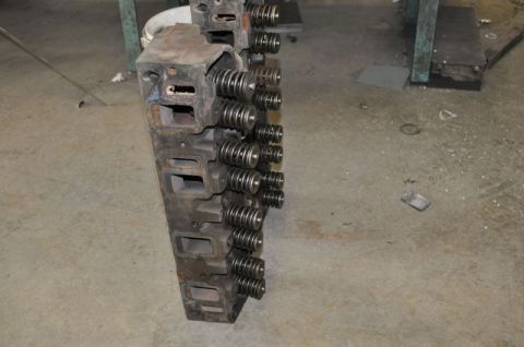 1996 Ford Bronco - Engine cylinder heads with valve springs are shown on a workshop floor.