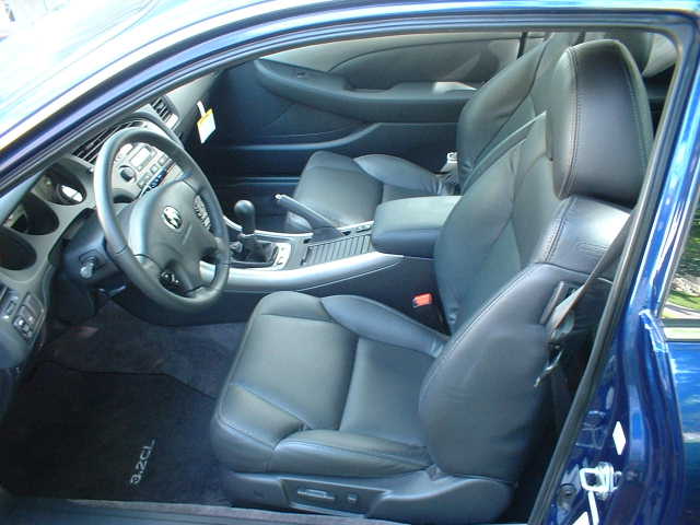 Black leather interior of a blue Acura 3.2CL coupe with '3.2CL' floor mats