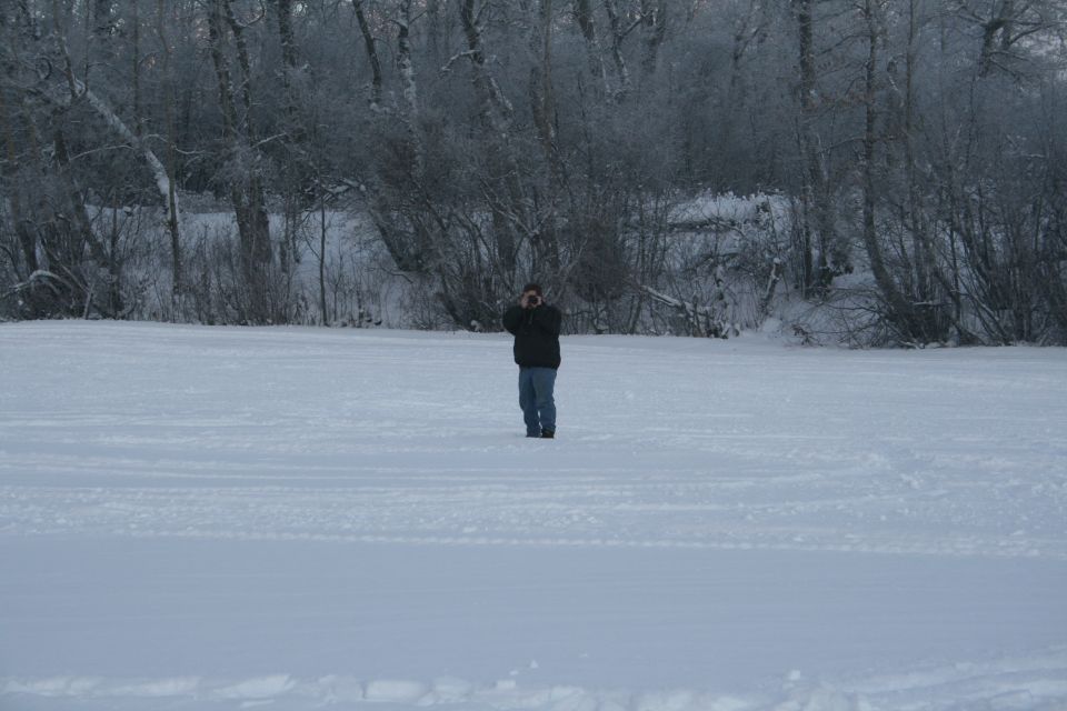 Person in a snowy field with a camera.