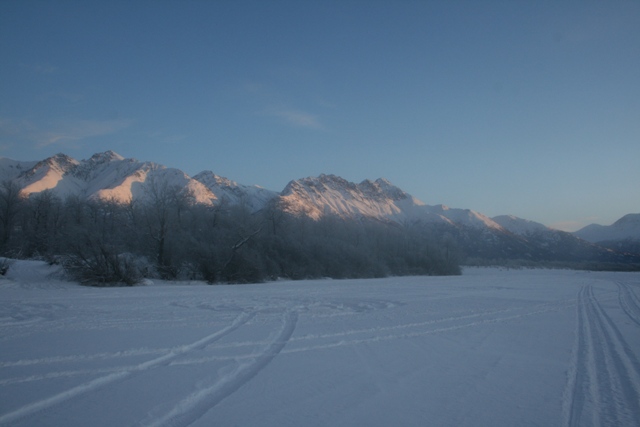 Snowy landscape with mountains under a clear blue sky