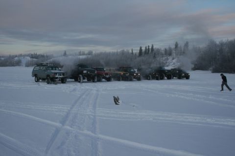 1990 Chevrolet Suburban - Multiple vehicles are visible in a vast, snow-covered landscape under an overcast sky.