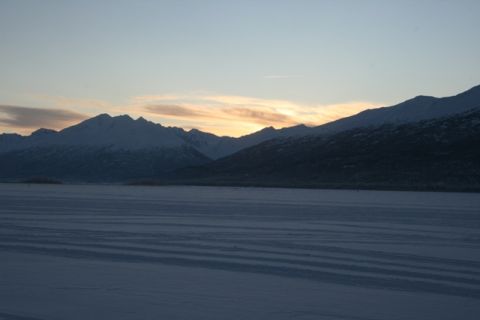 1990 Chevrolet Suburban - Winter sunset over a vast, snow-covered landscape with distant mountains.