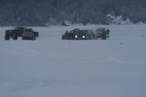 1990 Chevrolet Suburban - Multiple vehicles traverse a vast, snow-covered landscape under a cloudy sky.
