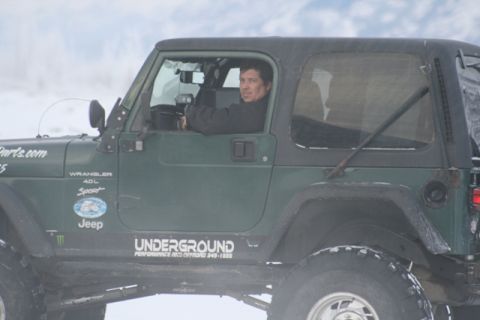 1990 Chevrolet Suburban - Man driving a green Jeep Wrangler in a snowy environment. Decals indicate "Wrangler 4.0L Sport" and "Jeep".
