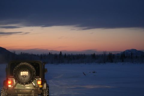 1990 Chevrolet Suburban - A Jeep Wrangler sits in a snowy landscape during a colorful dusk sky.
