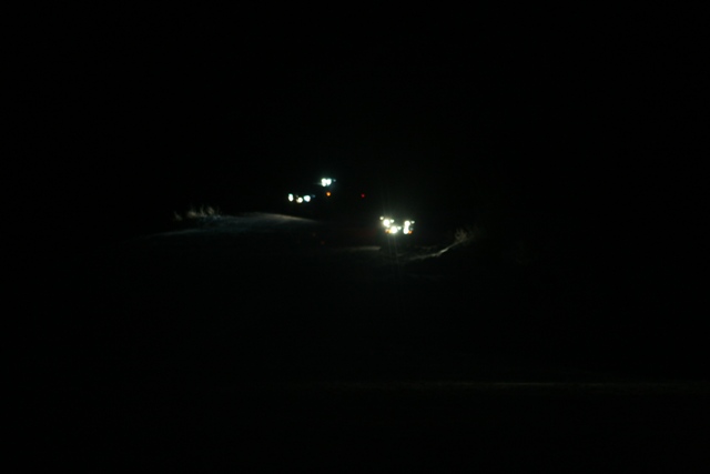 Headlights of a vehicle shine in the dark