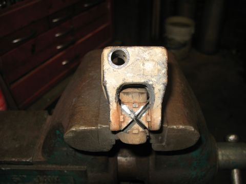 1978 Ford Bronco - A close-up view of a metal steering column component secured in a vise, with visible fasteners and modifications.