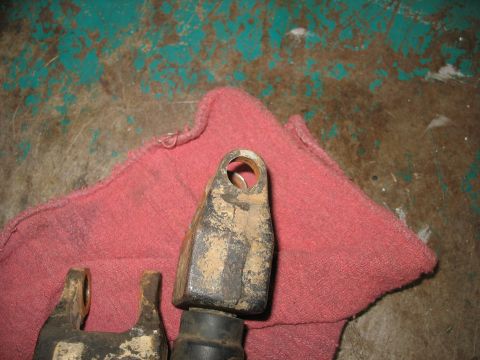 1978 Ford Bronco - Close-up of two dirty metal steering linkage components resting on a red cloth.