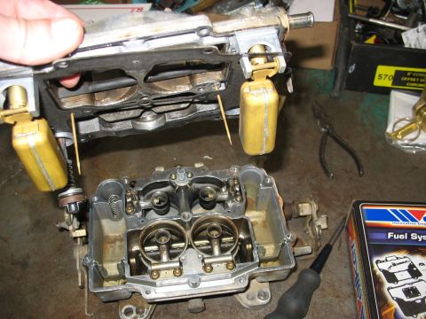 1978 Ford Bronco - Close-up of a disassembled carburetor, showing float bowls and internal components.