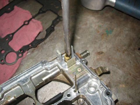 1978 Ford Bronco - A screwdriver is used to adjust a part on a carburetor, with a gasket visible in the background.