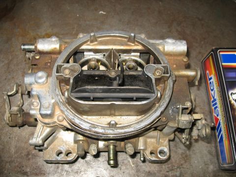 1978 Ford Bronco - A carburetor sits on a surface next to a box with a Walker logo.