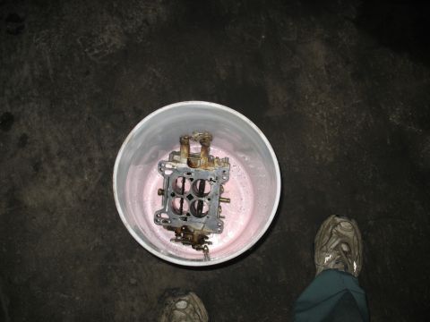 1978 Ford Bronco - Carburetor being cleaned in a bucket. The album claims it's from a 1978 Ford Bronco, but this is unlikely.