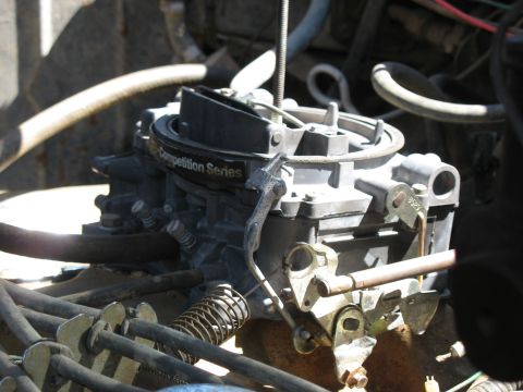 1978 Ford Bronco - A detailed view of a carburetor, identified as part of the "Competition Series", showing its intricate mechanical components and linkages.