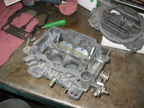 1978 Ford Bronco - Disassembled carburetor components laid out on a workbench for repair or cleaning.