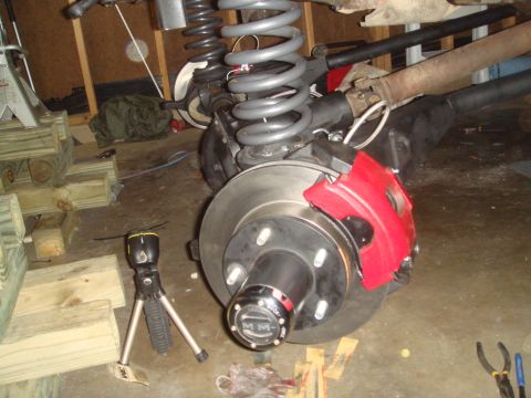 1992 Ford Bronco - A vehicle's suspension and brake system are shown in detail, with a red caliper and hub assembly as the focal point.