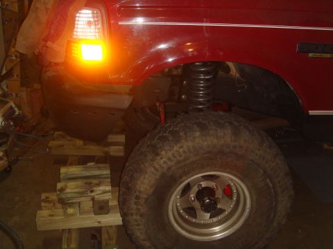 1992 Ford Bronco - Close-up of a 1992 Ford Bronco's side, highlighting the fender, large tire, and suspension.